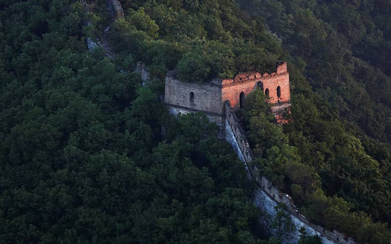 برج نگهبانی و دیوارهای قدیمی در میان درختان کوهستان