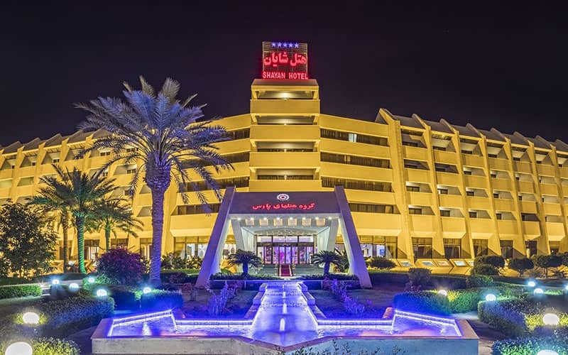 ساختمان هتل شایان با نورپردازی آبی و زرد در شب