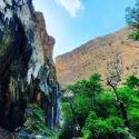 آبشار مارگون در مقابل درختان انبوه کوهستانی از نمای کنار