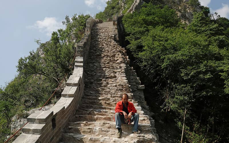مردی چینی روی پله های دیوار چین
