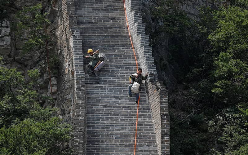 کارگرانی در حال پایین آمدن از پله های دیوار چین