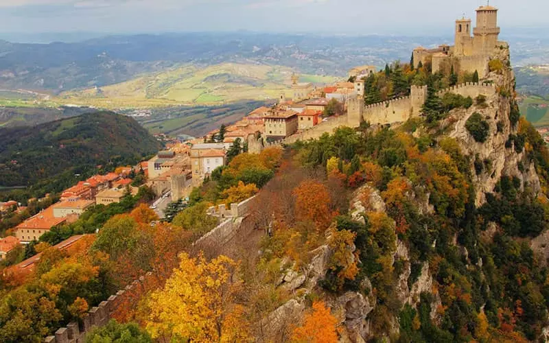 قلعه و خانه های مسکونی روی کوهستانی رنگارنگ در پاییز