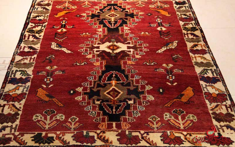 فرش دستبافت زیبایی با زمینه قرمز و طرح پرنده و گل