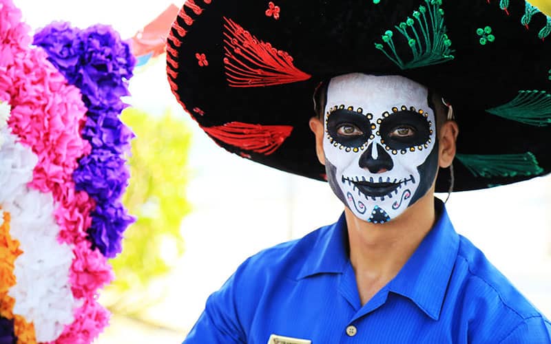 مرد جوانی با صورت نقاشی شده و کلاه مکزیکی