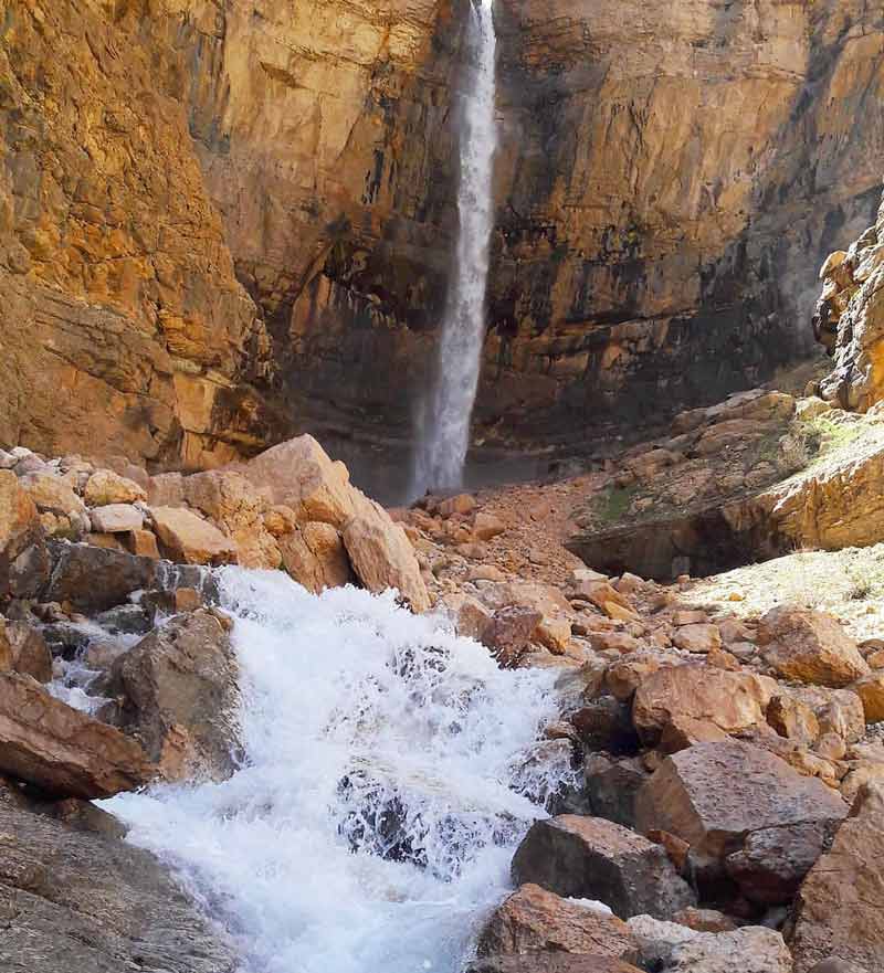 آبشار خفر بین کوه های صخره ای از نمای دور