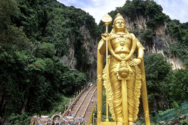 مجسمه طلایی خدای موروگان کنار پله های غار میمون مالزی از پایین