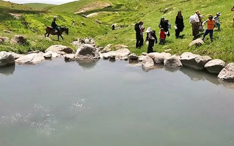 حضور گردشگران در کنار چشمه آب
