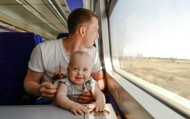 کودک و پدر در قطار کنار پنجره