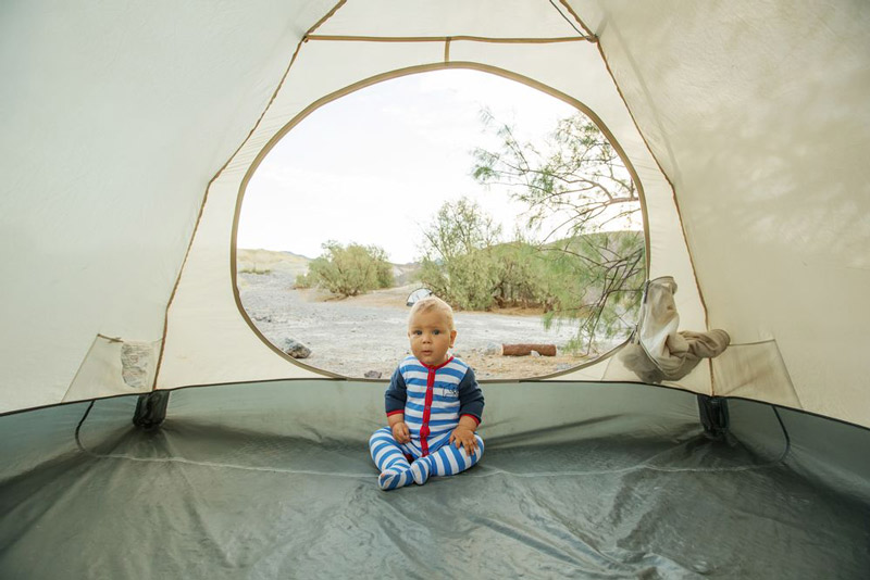 کودک در چادر کمپینگ در طبیعت