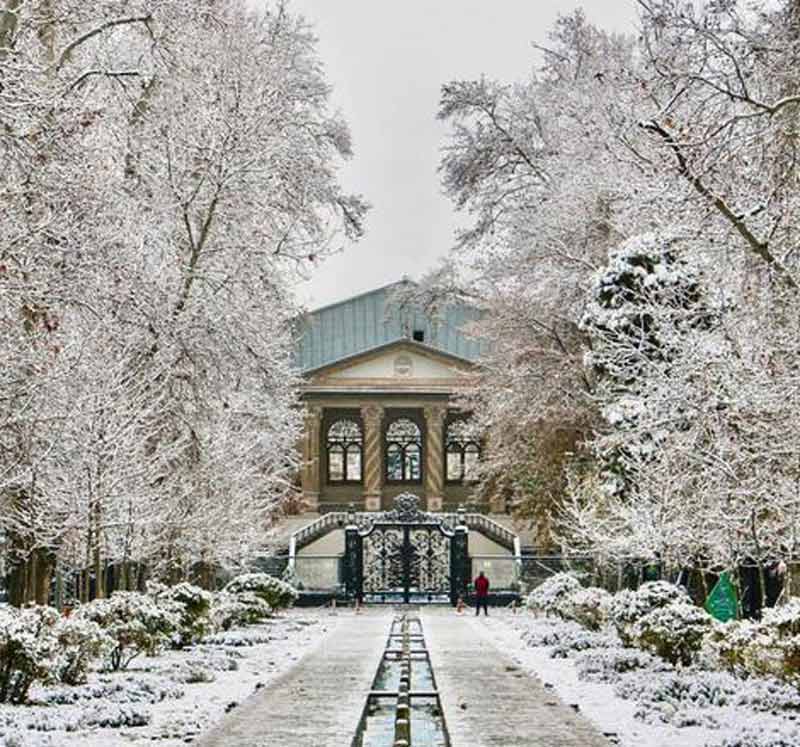 عمارت باغ گلستان تهران مقابل حوض و درختان پوشیده از برف