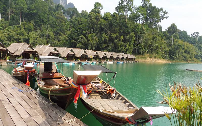 چند قایق چوبی و کلبه در دریاچه چیو لان