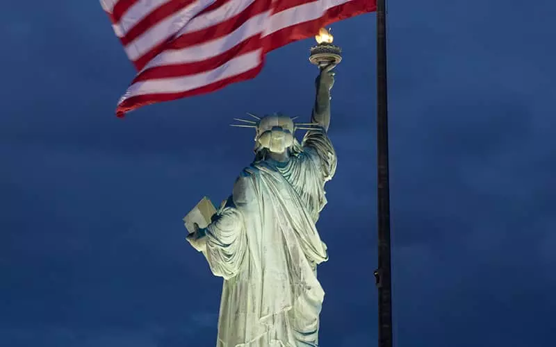 تصویر مجسمه آزادی در کنار پرچم آمریکا 