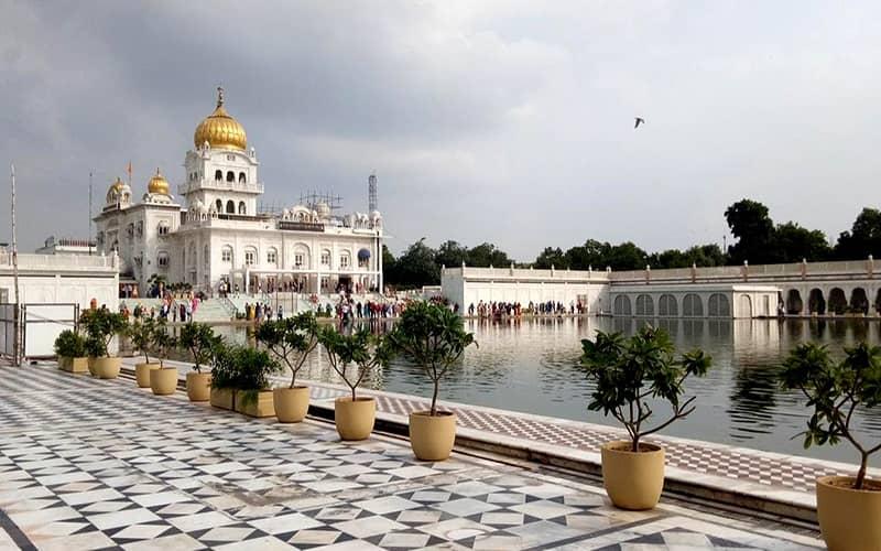 عمارت سفیدرنگ گورودوارا بنگلا صاحب با گنبد طلایی و استخری بزرگ