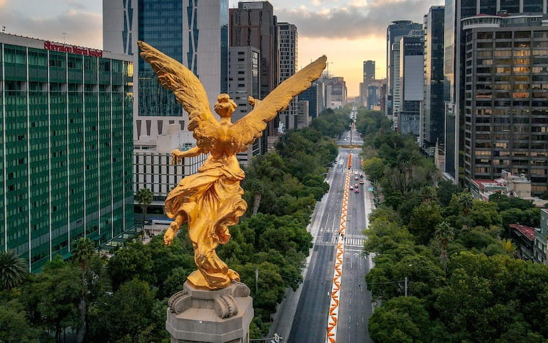 مجسمه طلایی یک زن بر فراز شهری در مکزیک