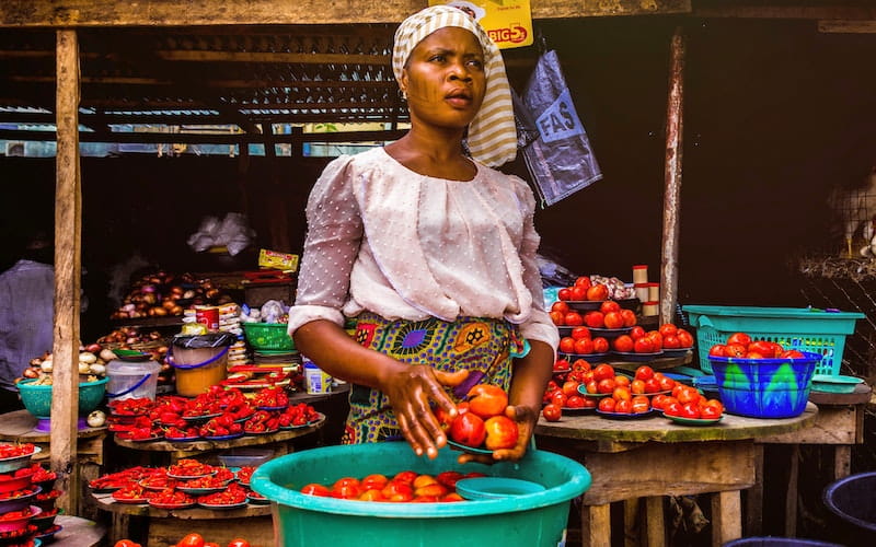 زنی آفریقایی در حال فروش گوجه فرنگی