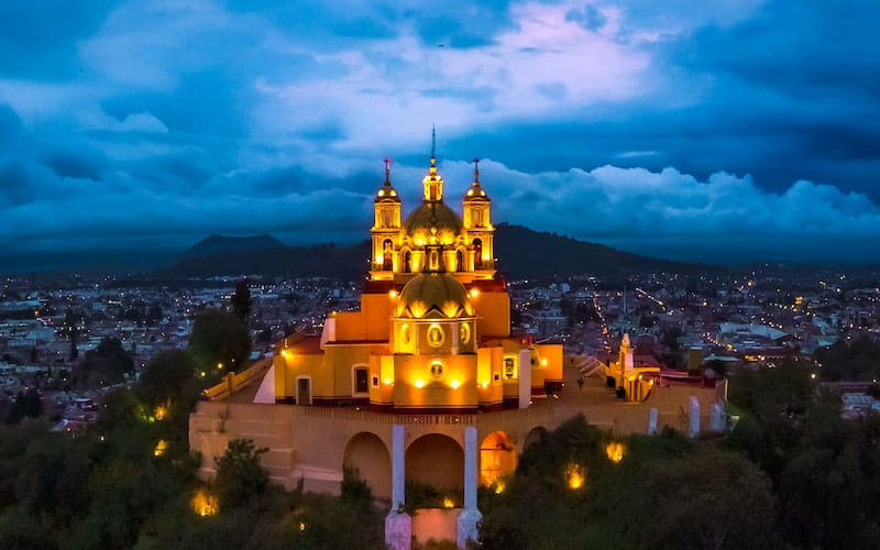 عمارتی چند طبقه و گنبددار در نورپردازی شب در مکزیک