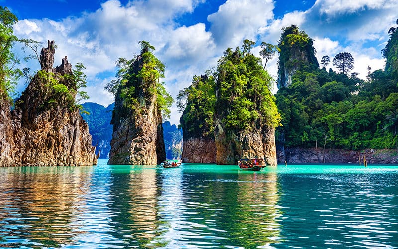 چندین صخره سرسبز در وسط دریا در تایلند