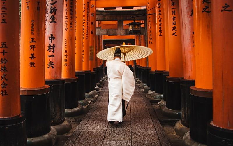 مردی با لباس سنتی ژاپنی در گذرگاه یک معبد