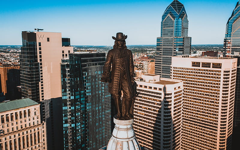 مجسمه برنزی مردی در میان آسمانخراش های آمریکا