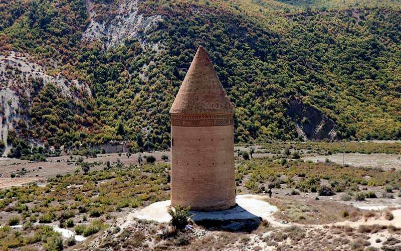 برجی آجری با گنبد هرمی در کوهستان