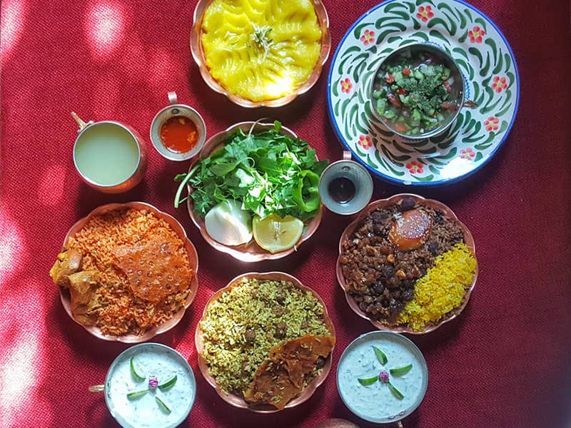 سفره ای با انواع غذاهای ایرانی و ماست و سبزی و سالاد