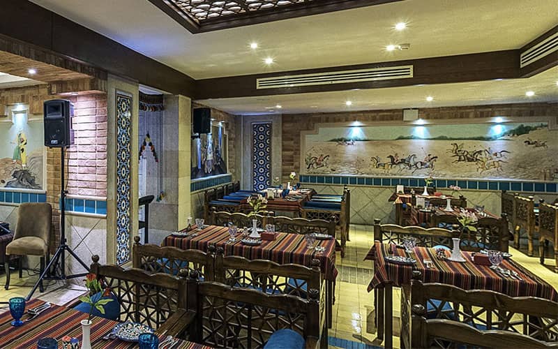 رستورانی سنتی با تخت های چوبی و نقاشی دیواری