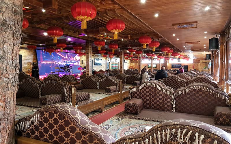 رستورانی سنتی با تخت چوبی و لوسترهای قرمز