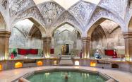 حمامی تاریخی با حوض بزرگ و سقف مزین به نقاشی
