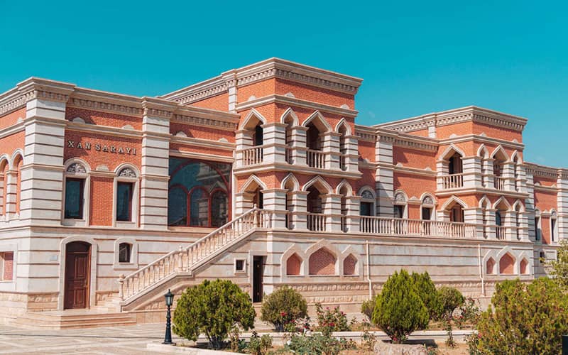 عمارتی تاریخی به رنگ سفید و نارنجی با نمای طاقی شکل