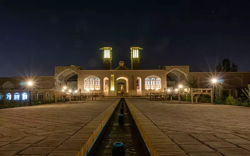عمارتی تاریخی با بادگیر و جوی آب در شب