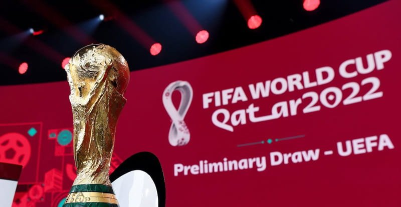 جام طلا مقابل لوگوی جام جهانی قطر