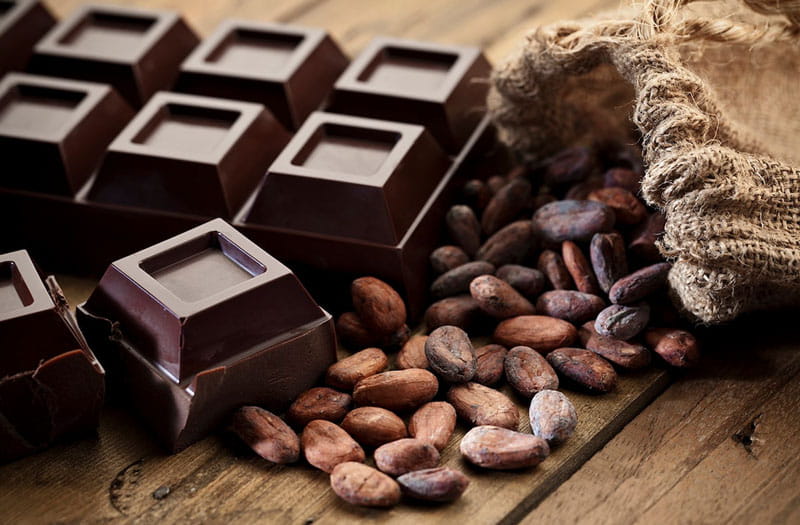 شکلات تلخ کنار دانه های قهوه ای کاکائو