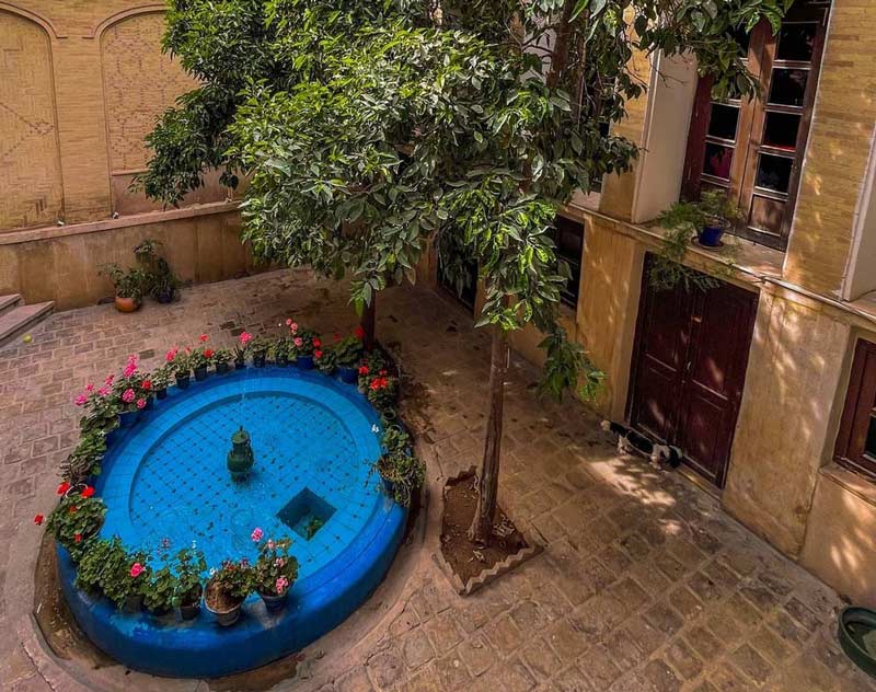 حیاط خانه پرهامی شیراز با حوض آبی مقابل ورودی خانه