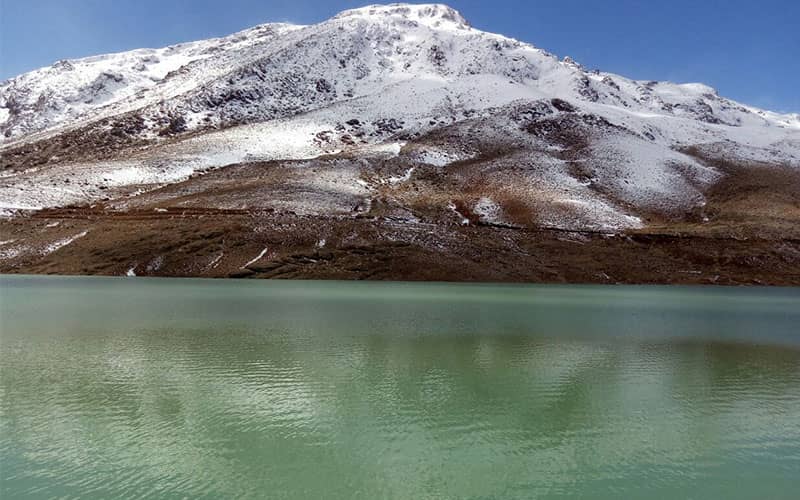 دریاچه‌ای پرآب جلوی کوهی مملو از برف
