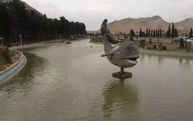 مجسمه ماهی وسط دریاچه ای در پارک