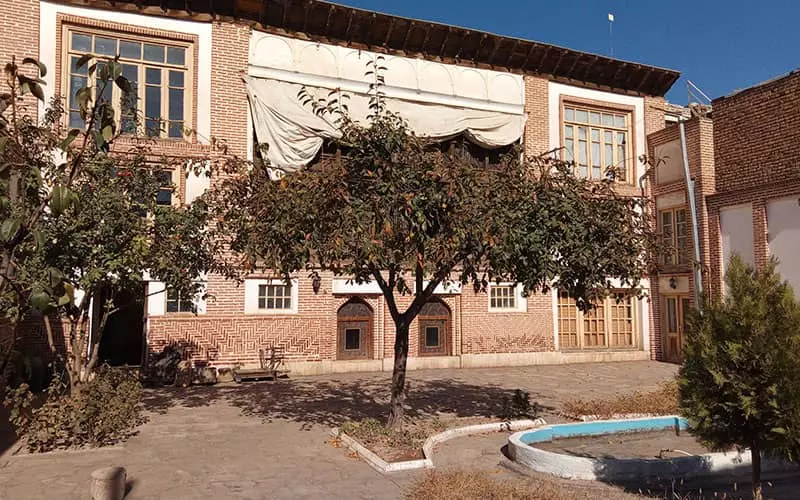 حیاط خانه ای تاریخی با حوض آب و درخت