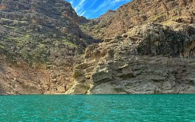 دریاچه ای پرآب و فیروزه‌ای در کنار کوهی بلند