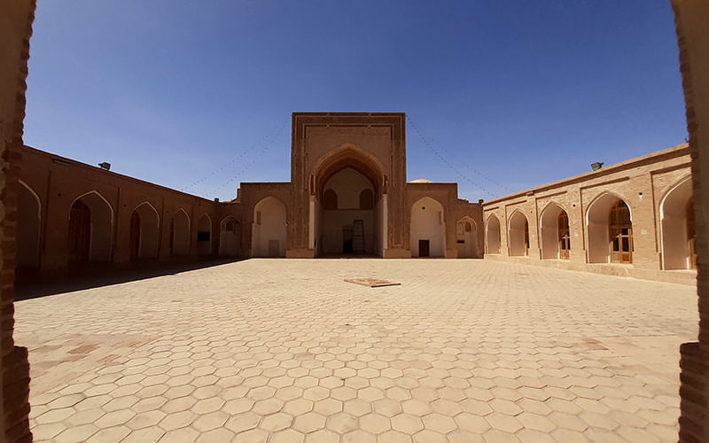 حیاط مسجدی بزرگ و تاریخی با ایوانی بلند