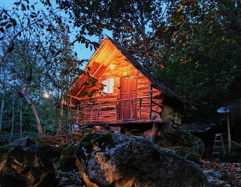 اقامتگاه بومگردی کلبه کومه در شب میان جنگل