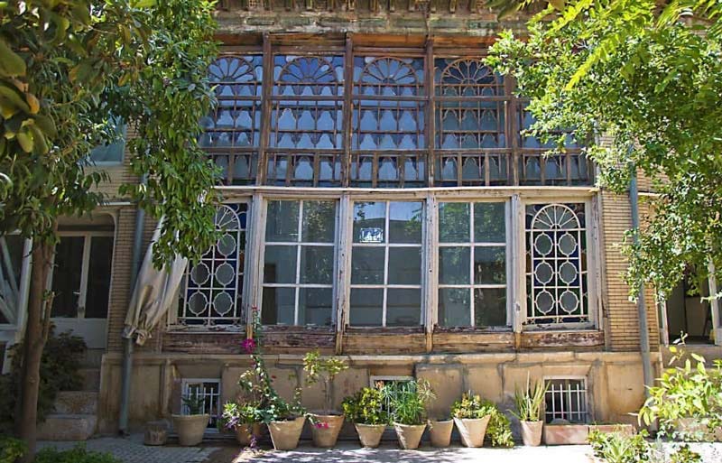 پنجره های عمارت صابر شیراز و گلدان های سبز زیر آن