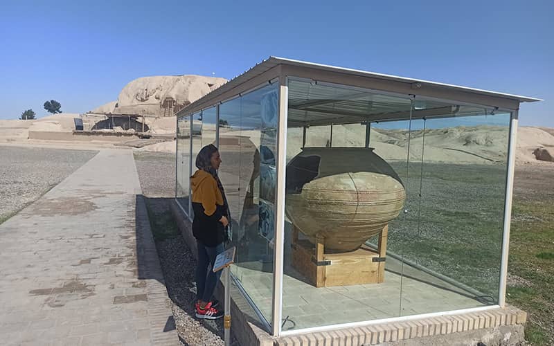گردشگری در کنار ویترین کوزه ای تاریخی در منطقه ای روباز