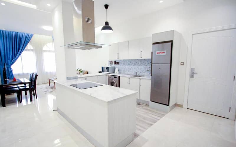 خانه ای به رنگ سفید با آشپزخانه اوپن و اتاق پذیرایی