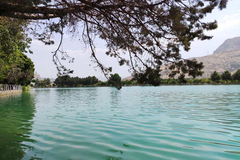 چشم‌اندازی از دریاچه کیو با قابی از برگ درختان