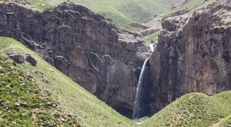 آبشار خور میان کوهستان های بلند از نمای دور
