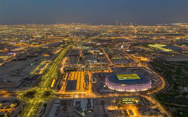 استادیومی بزرگ و مدور در منطقه ای با چندین بزرگراه در نورپردازی شب
