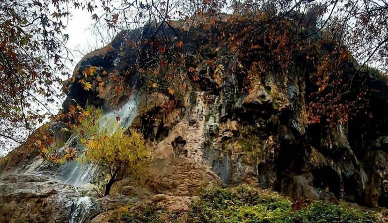 آبشار کمرد میان صخره های پوشیده از برگ های پاییزی