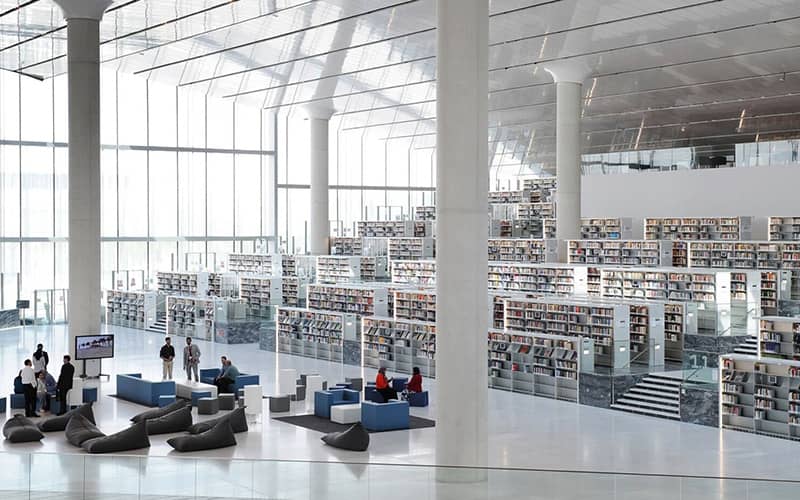 کتابخانه بسیار بزرگی با سقف بلند و دکوراسیون سفید