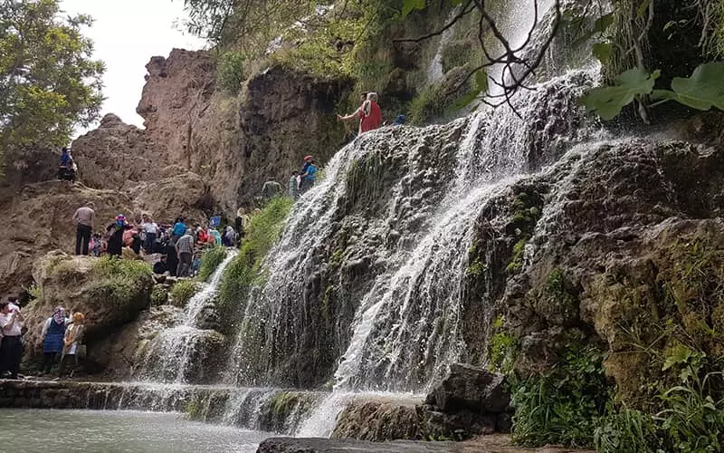 حضور گردشگران در کنار آبشاری پرآب