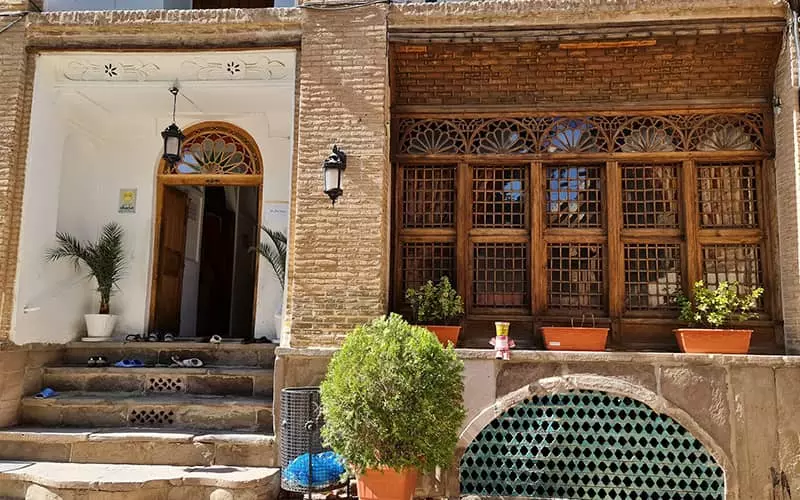 حیاط عمارتی تاریخی با پنجره های چوبی