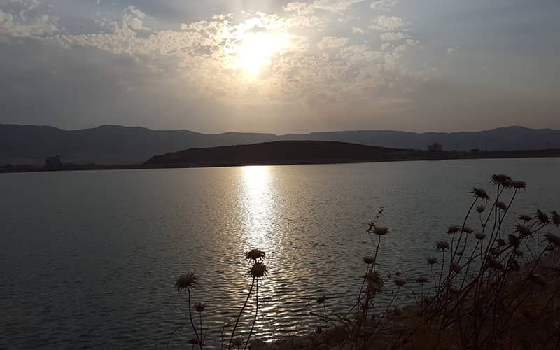 دریاچه ای پرآب در زمان غروب خورشید